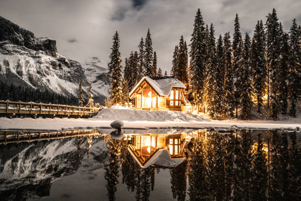 lac d'émeraude avec pavillon dans le parc national yoho, colombie-britannique, canada; tourné la nuit avec des lumières allumées dans la réflexion chalet sur le lac - british columbia canada lake emerald lake photos et images de collection