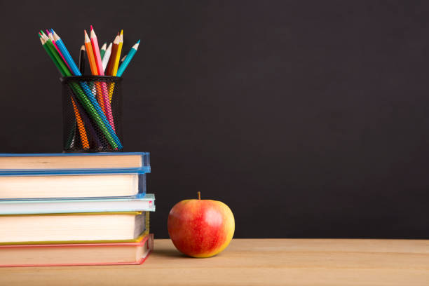 istock Office stationery and fresh apple over chalk board 1165471039
