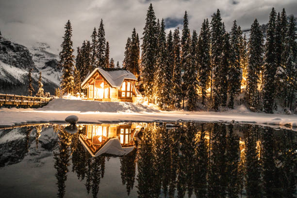 lac d'émeraude avec pavillon dans le parc national yoho, colombie-britannique, canada; tourné la nuit avec des lumières allumées dans la réflexion chalet sur le lac - british columbia canada lake emerald lake photos et images de collection