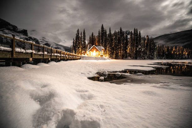 emerald lake with lodge in yoho national park, british columbia, canada; shot at night with lights on in the chalet reflection on lake - british columbia canada lake emerald lake imagens e fotografias de stock