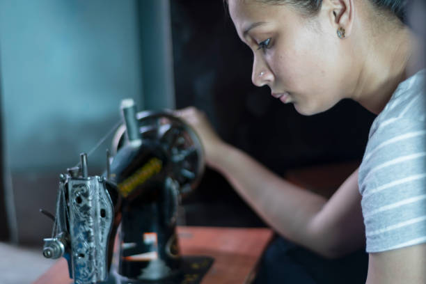 istock girl sewing cloths by sewing machine at home 1165472240