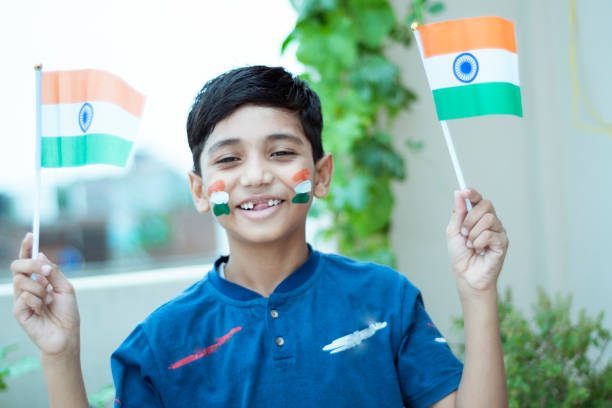 istock happy little Indian boy holding Indian flag with pride 1165473808