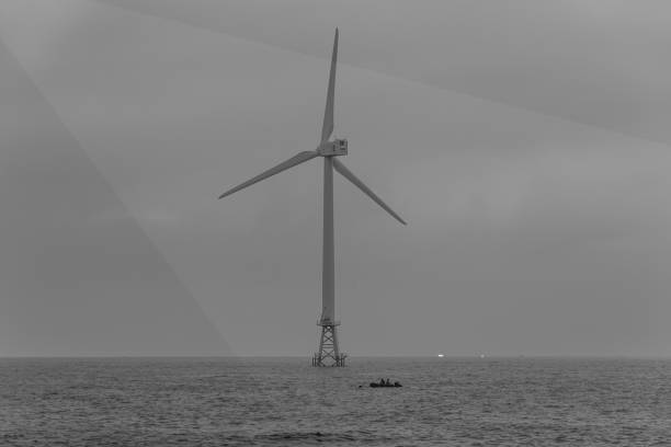 A view of the coast and wind power generator installed in the sea A view of the coast and wind power generator installed in the sea, Jeju korea floating electric generator stock pictures, royalty-free photos & images