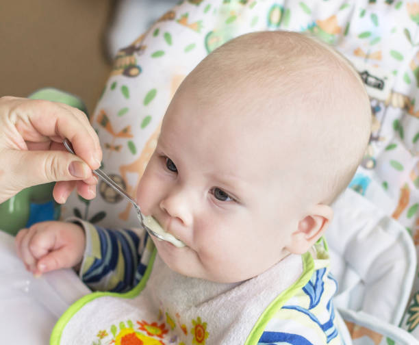 istock Baby fed with a spoon 1165474201