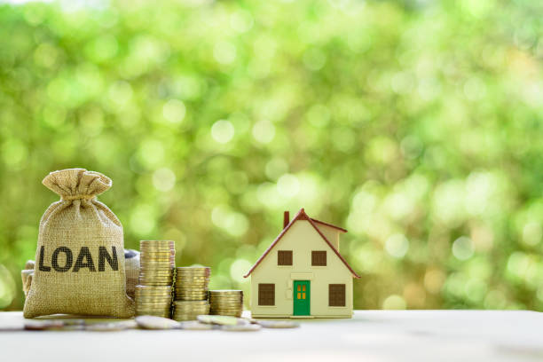 Mortgage-backed security MBS, financial concept : House model, stacks of rising coins, loan bags on a table over green background, depicts raising fund from a bank to buy home or properties or assets seguridad respaldada por hipotecas mbs, concepto financiero : modelo de la casa, pilas de monedas crecientes, bolsas de préstamo en una mesa sobre fondo verde, representa la recaudación de fondos de un banco para comprar casa o propiedades o activos