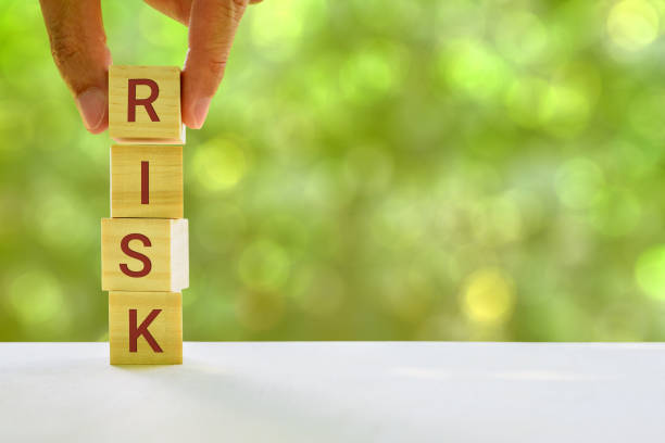 istock Financial risk assessment and portfolio risk management concept : Stack of vertical 4 cubes on a table with a letter R, I, S, K on each cubes, depicts managing / control asset risk to gain high return 1165478951