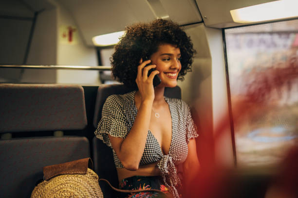 istock Beautiful woman talking on mobile in train 1165480227