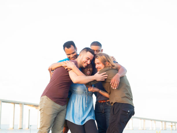 istock Happy friends hugging in park 1165480513