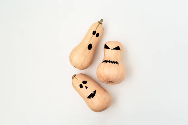 istock Funny scary face Halloween pumpkins on black background. Flat lay, top view background. 1165483115