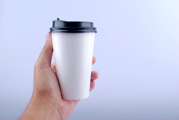 istock Male hand holding a Coffee paper cup isolated on white background. 1165486113