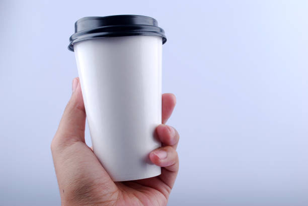 istock Male hand holding a Coffee paper cup isolated on white background. 1165486117