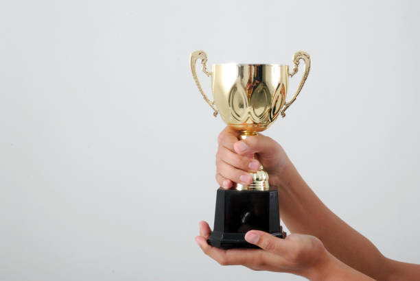 istock Man holding a champion golden trophy 1165486795