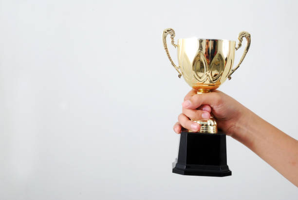 istock Man holding a champion golden trophy 1165486801