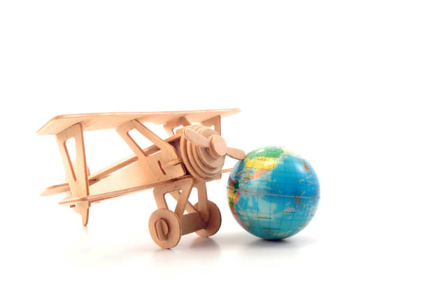 Wooden toy airplane and mini globe on white background