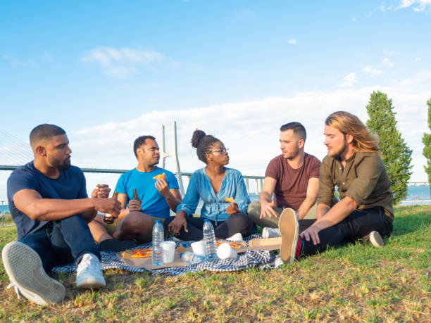 istock Relaxed good friends having picnic in park 1165488358