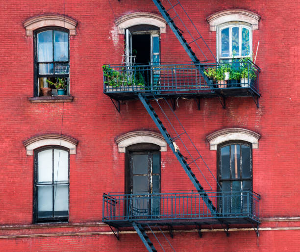 istock Red apartment building with old windows, plants and stairs. 1165489083