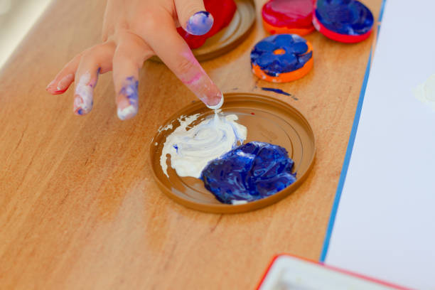 istock Child's hand mixing paint, gouache, watercolor while drawing 1165489666
