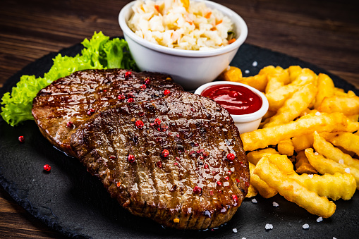 Grilled steak with French fries and vegetable salad