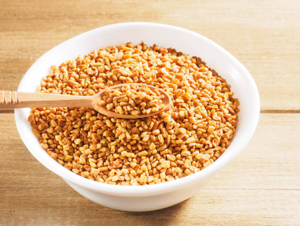 istock Fenugreek (Trigonella) in a ceramic white cup with spoon on a wooden background 1165490340