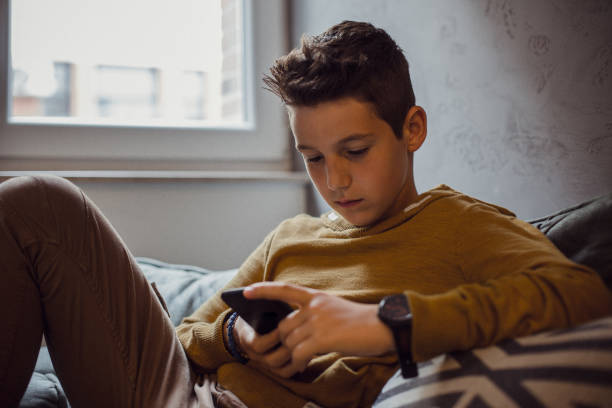 teenage boy relaxing in seinem schlafzimmer - 12 13 jahre stock-fotos und bilder