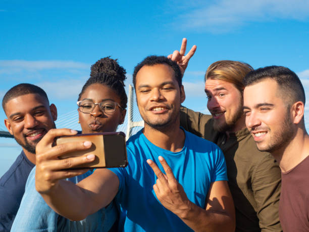 istock Smiling friends gesturing while taking self portrait with smartphone. 1165492072