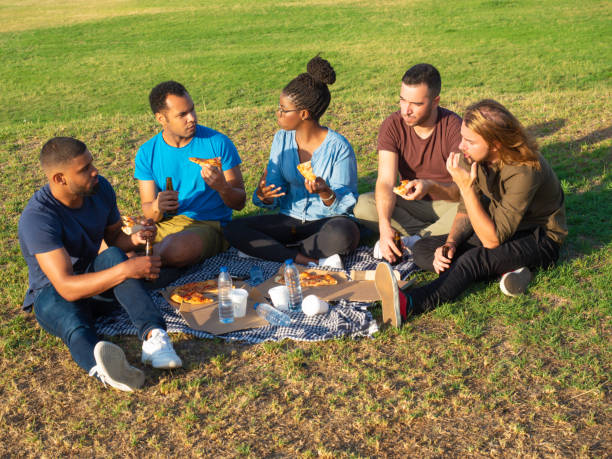 Relaxed friends having picnic in park
