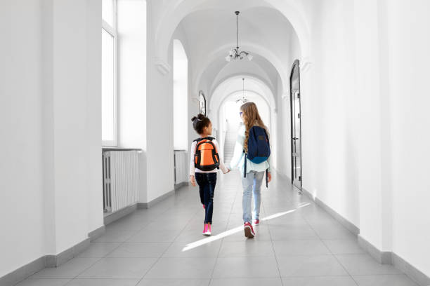 istock Back view of two girls going forward at school. 1165492564