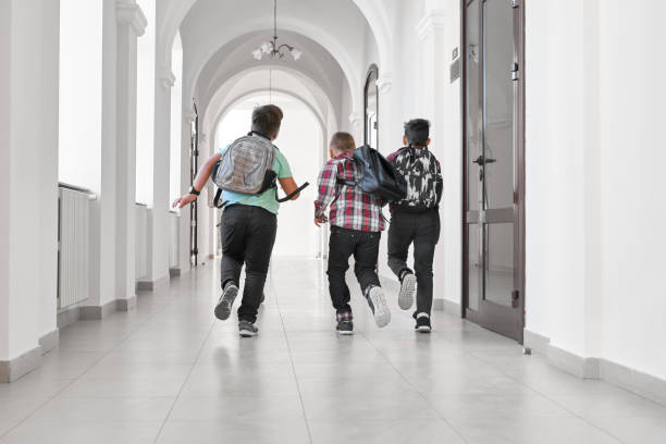 istock Group of schoolboys with school backpacks running. 1165492576