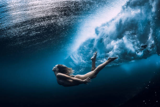 istock Woman swim underwater with ocean wave. 1165493248