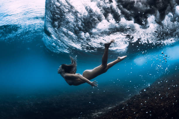 istock Woman swim underwater with ocean wave. 1165493255