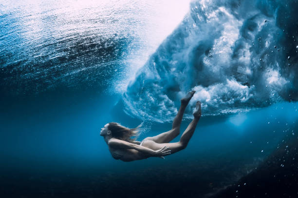 istock Woman swim underwater with ocean wave. 1165493346