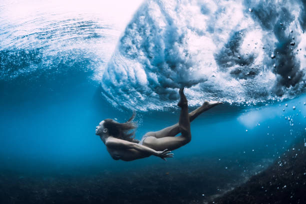 istock Woman swim underwater with ocean wave. 1165493347