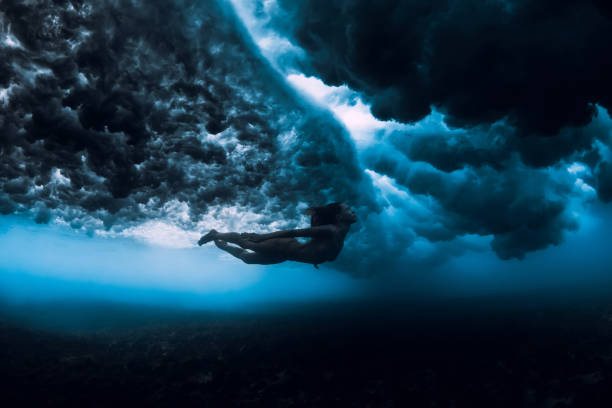 istock Woman dive underwater with ocean wave. 1165493384