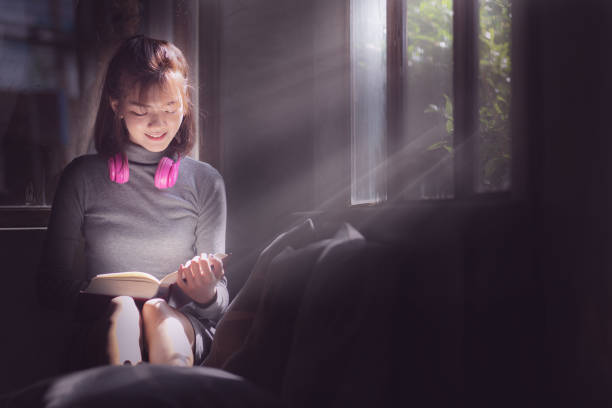 istock Asia woman reading book with happy. 1165493570