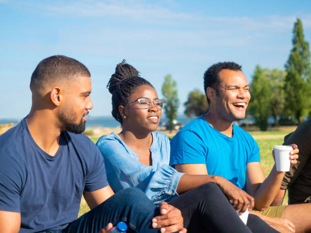 istock Cheerful young friends gathering in park 1165494544
