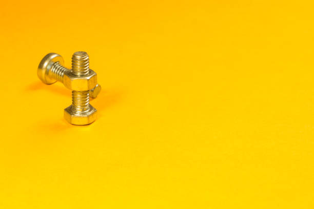 istock Steel screws on a yellow background 1165495080