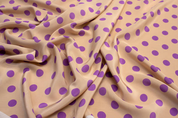 istock The texture of silk fabric with lilac peas on beige. Background, pattern. 1165496611