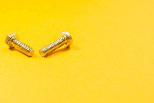 istock Steel screws on a yellow background 1165498302