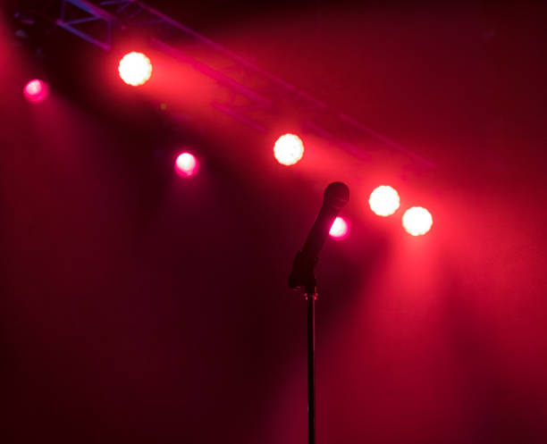 istock Microphone on stage with stage-lights in the background. 1165498306