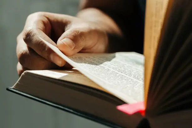 Photo of Close up of young man hands hold and reading holy bible.Christian faith concept