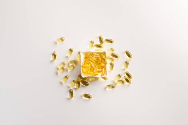 istock Bowl with fish oil capsules, isolated on white background. Flat lay. 1165500233