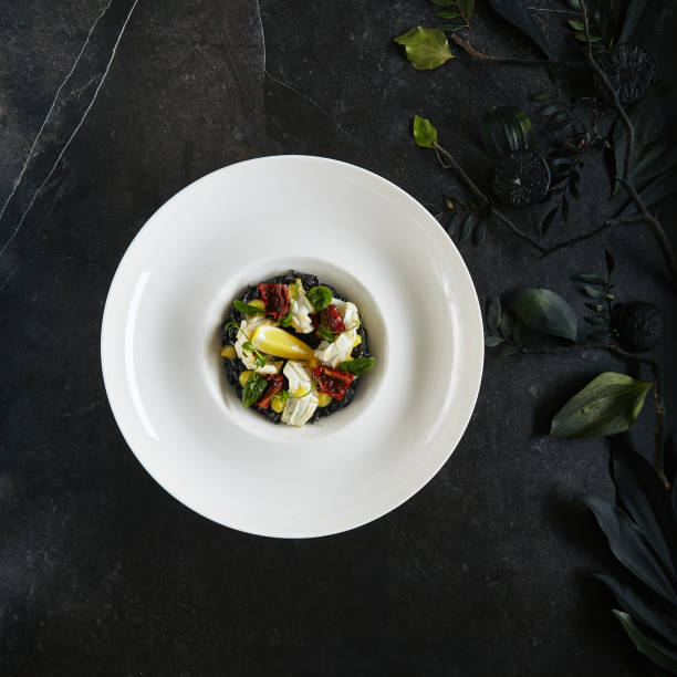 istock Exquisite Serving White Restaurant Plate of Black Risotto with Octopus, Cuttlefish or Squid Meat Top View 1165501300
