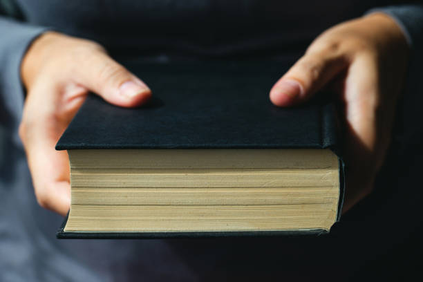 istock Sunday readings, Bible.Close up man hands holding Bible 1165502829