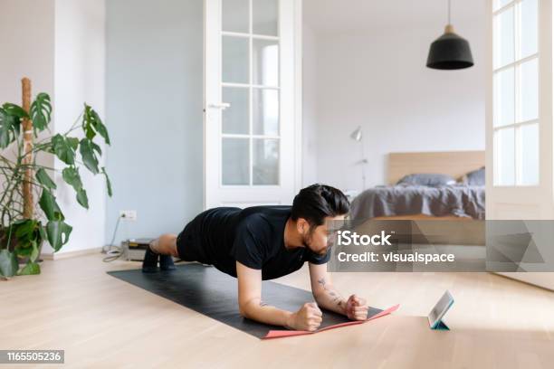 Foto de O Homem Asiático Usa A Tabuleta Digital Para Inclinar A Posição Da Prancha e mais fotos de stock de Exercício físico