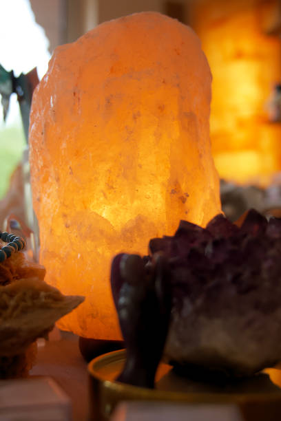 istock Himalayan salt lamp on wooden table illuminated 1165505246