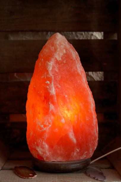 istock Himalayan salt lamp on wooden table illuminated 1165505250