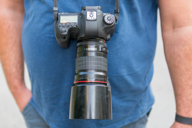 istock photographer with a camera hanging on his neck. 1165505271