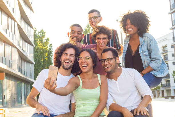 istock Happy excited Latin woman taking group selfie 1165505634