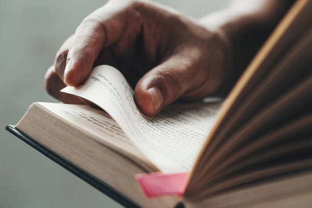istock Close up man hands.Young man opening and reading a book, 1165505698