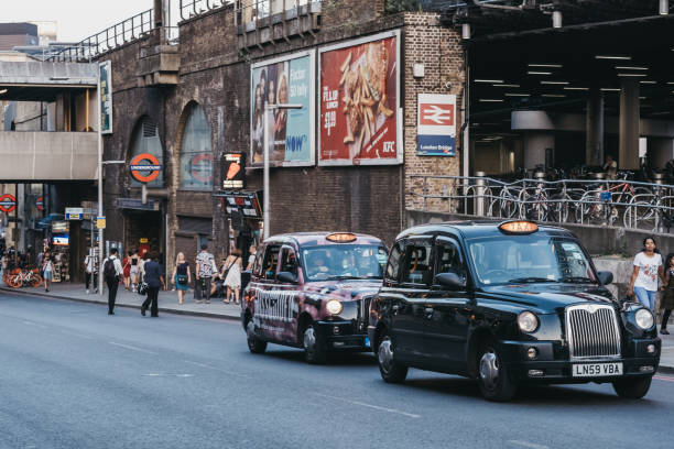 London, UK - July 23, 2019: Hackney carriage black cabs on a road outside London Bridge Station. Black cabs are one of the icons of the city.